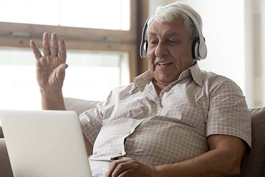 Elderly man on a video call to receive counseling online from QuitNow.net.